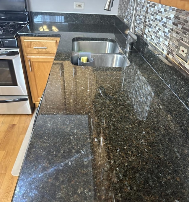 6255 S Mason Ave Unit 3D, Chicago, IL 60638 - room details featuring a sink, dark stone countertops, backsplash, and stainless steel gas range