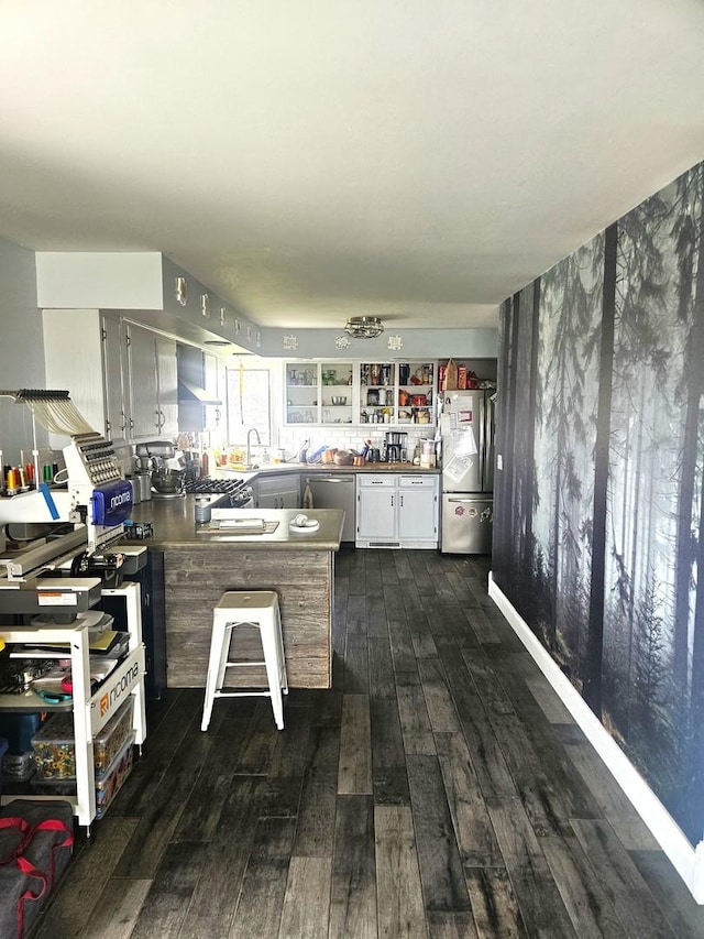 8554 S Daysville Rd, Franklin Grove, IL 61031 - kitchen with a peninsula, dark wood-type flooring, appliances with stainless steel finishes, wall chimney range hood, and white cabinetry