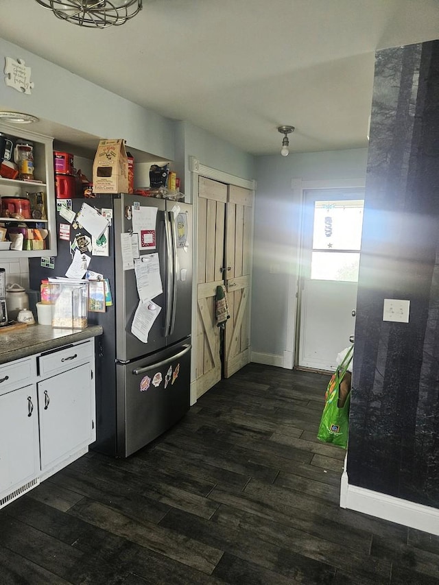 8554 S Daysville Rd, Franklin Grove, IL 61031 - kitchen with freestanding refrigerator, dark wood-style floors, dark countertops, white cabinets, and baseboards
