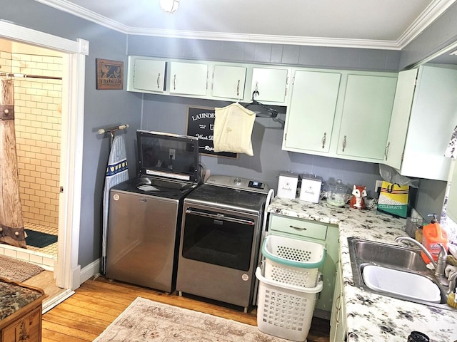 8554 S Daysville Rd, Franklin Grove, IL 61031 - kitchen featuring washing machine and dryer, a sink, light wood-style floors, crown molding, and light countertops