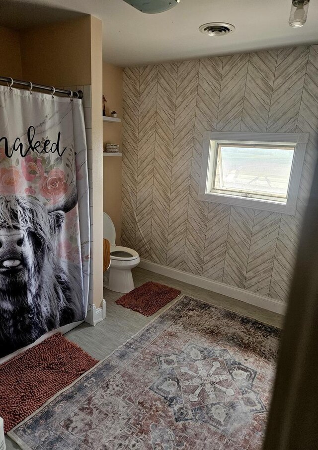 8554 S Daysville Rd, Franklin Grove, IL 61031 - full bath with toilet, a shower with shower curtain, baseboards, wood finished floors, and wallpapered walls
