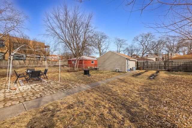 view of yard with a fenced backyard, an outdoor structure, a patio area, and a residential view