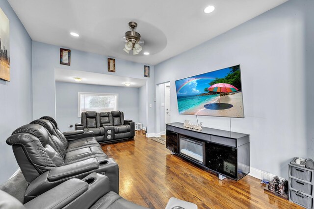 living area featuring baseboards, ceiling fan, recessed lighting, and wood finished floors