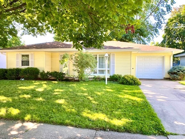 ranch-style home featuring an attached garage, driveway, and a front yard