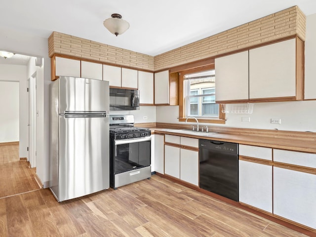 14216 S Normal Ave, Riverdale, IL 60827 - kitchen featuring a sink, white cabinets, black appliances, and light wood-type flooring
