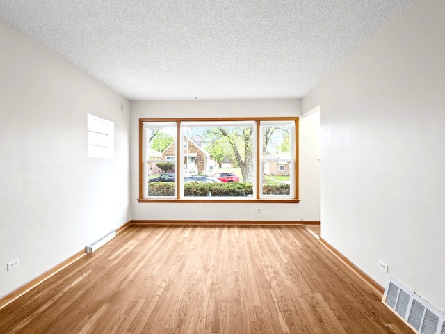 14216 S Normal Ave, Riverdale, IL 60827 - unfurnished room with baseboards, a textured ceiling, visible vents, and wood finished floors