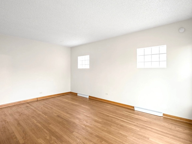 14216 S Normal Ave, Riverdale, IL 60827 - spare room featuring baseboards, light wood-style flooring, baseboard heating, and visible vents