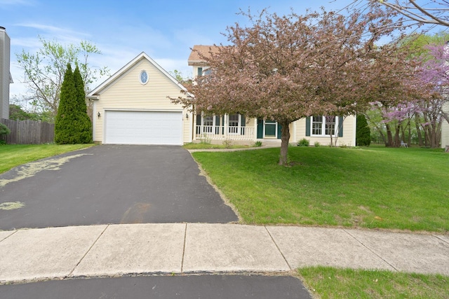 obstructed view of property with aphalt driveway, fence, an attached garage, and a front lawn