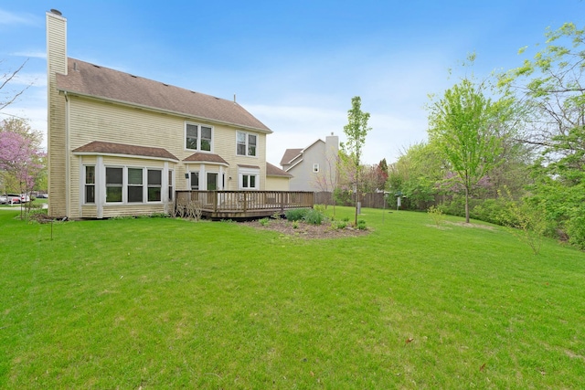 back of house with a yard, a chimney, and a wooden deck