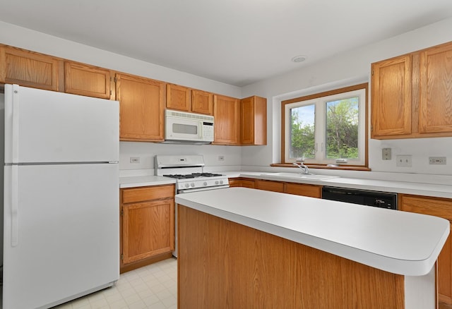 kitchen with a sink, white appliances, light floors, light countertops, and a kitchen island