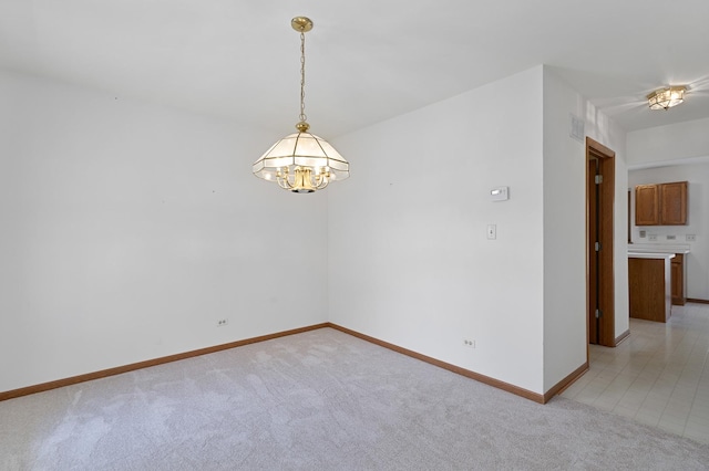 unfurnished room featuring baseboards, a notable chandelier, light carpet, and visible vents