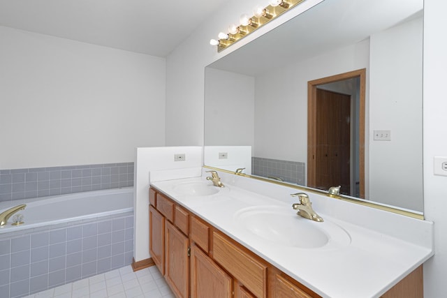 bathroom featuring double vanity, tile patterned flooring, tiled tub, and a sink