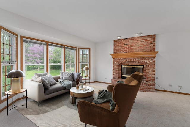 living area with light colored carpet, a wealth of natural light, baseboards, and a brick fireplace