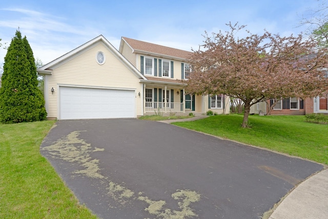 traditional home with an attached garage, a porch, a front lawn, and aphalt driveway