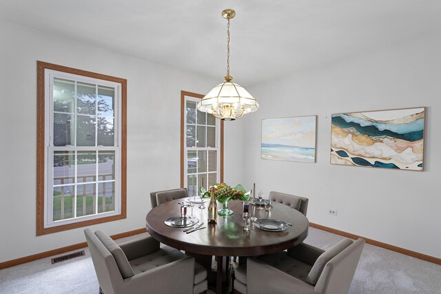 dining area with carpet flooring, visible vents, baseboards, and a notable chandelier