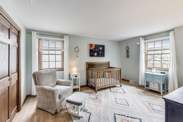 1608 N Douglas Ave, Arlington Heights, IL 60004 - bedroom featuring multiple windows, light wood finished floors, baseboards, and a nursery area