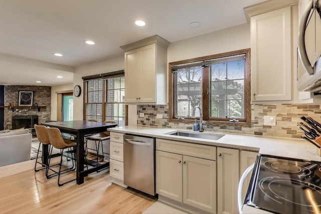 1608 N Douglas Ave, Arlington Heights, IL 60004 - kitchen with appliances with stainless steel finishes, a sink, a fireplace, light countertops, and decorative backsplash