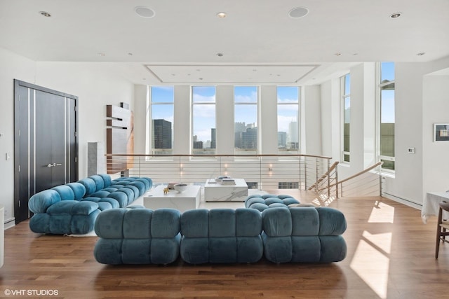 living room featuring a view of city, floor to ceiling windows, and wood finished floors