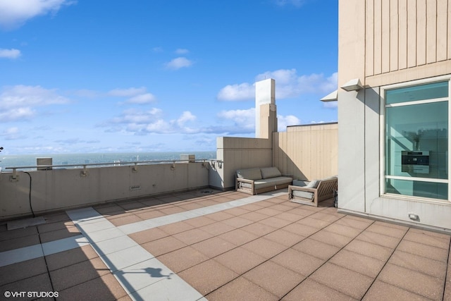 view of patio / terrace with a water view and a balcony
