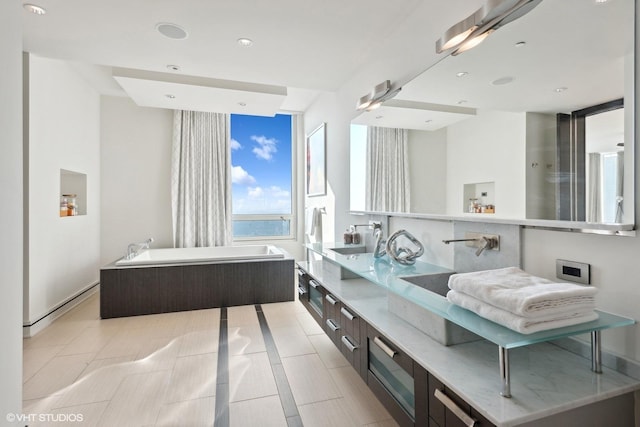 bathroom featuring recessed lighting, double vanity, and a bath