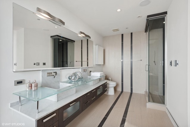 full bathroom featuring double vanity, a stall shower, tile patterned floors, toilet, and recessed lighting