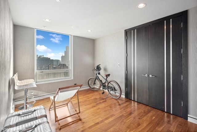 sitting room with a view of city, recessed lighting, and wood finished floors