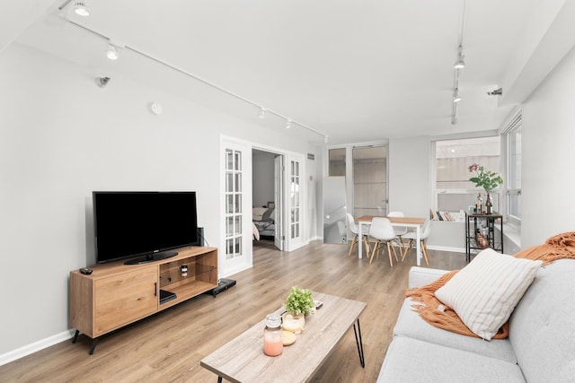345 N La Salle Dr Unit 1205, Chicago, IL 60610 - living room featuring track lighting, baseboards, french doors, and light wood-type flooring