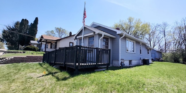 exterior space with a yard, a wooden deck, and central AC