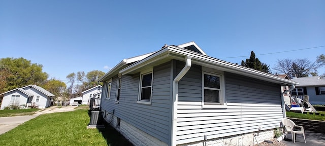 view of home's exterior featuring cooling unit and a lawn