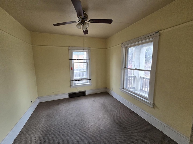 carpeted empty room featuring baseboards and ceiling fan