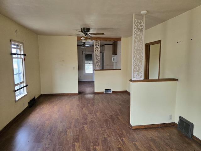 unfurnished room with baseboards, plenty of natural light, dark wood-style flooring, and visible vents