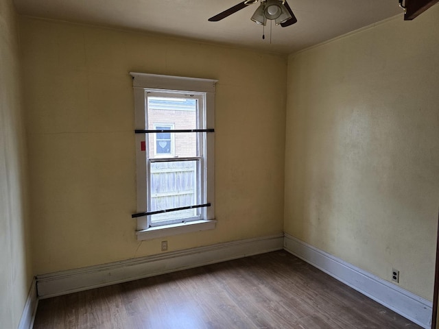 empty room with baseboards, a ceiling fan, and wood finished floors
