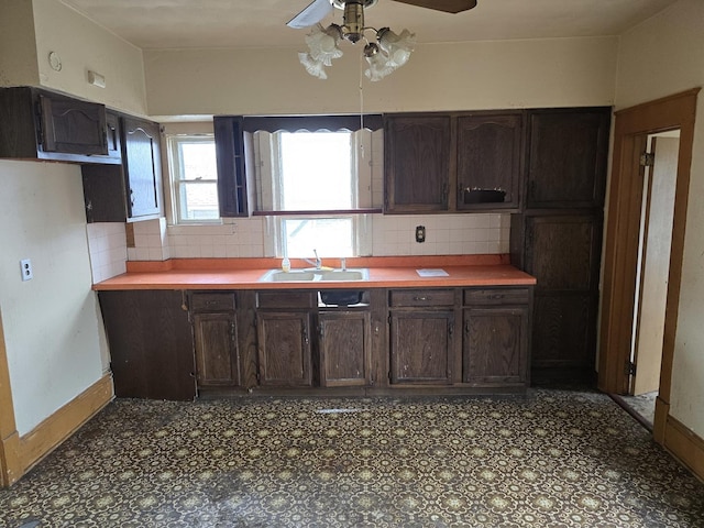 kitchen with tile patterned floors, dark brown cabinetry, and a sink