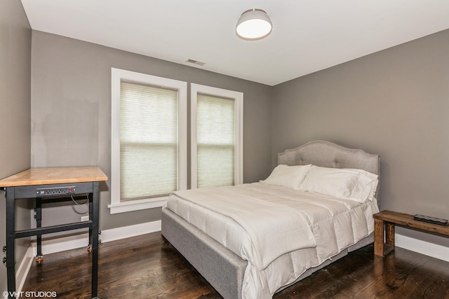 bedroom featuring dark wood finished floors, visible vents, and baseboards