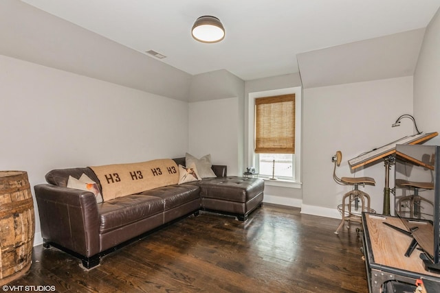 living area with baseboards, visible vents, and wood finished floors