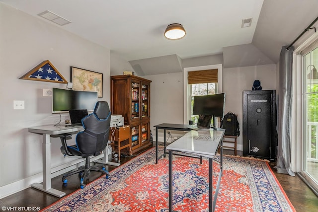 office featuring vaulted ceiling, baseboards, visible vents, and wood finished floors