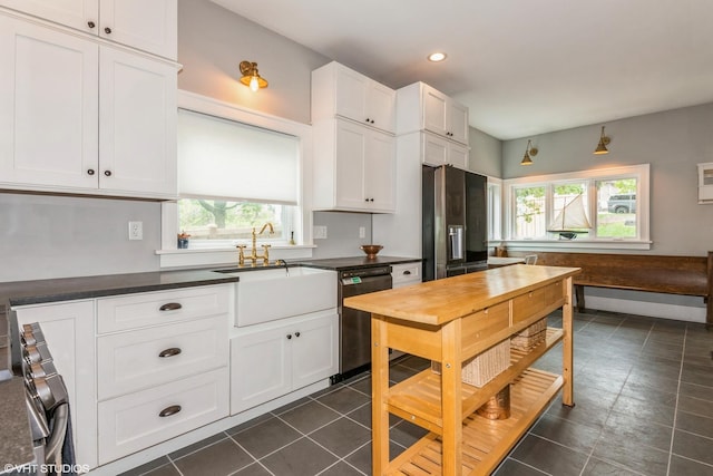 kitchen featuring dishwasher, a wealth of natural light, stainless steel refrigerator with ice dispenser, and a sink