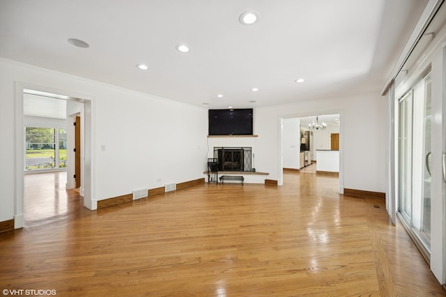 1050 Cedar Ln, Lake Forest, IL 60045 - unfurnished living room featuring a fireplace with raised hearth, a chandelier, recessed lighting, ornamental molding, and baseboards