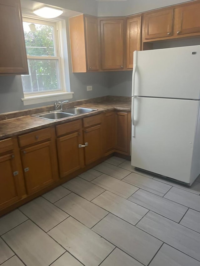 14534 S Grant St, Dolton, IL 60419 - kitchen featuring freestanding refrigerator, brown cabinets, dark countertops, and light tile patterned flooring