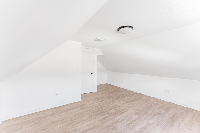 bonus room featuring baseboards, light wood-style flooring, and lofted ceiling
