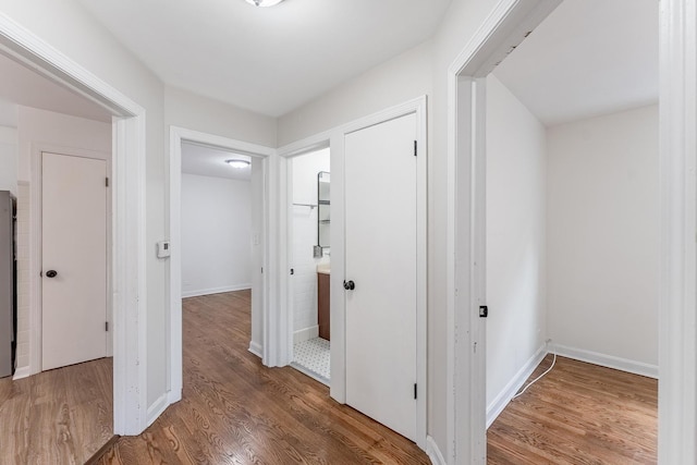 hallway featuring baseboards and wood finished floors