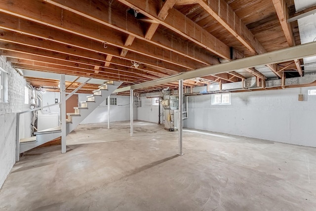 basement featuring stairs and water heater