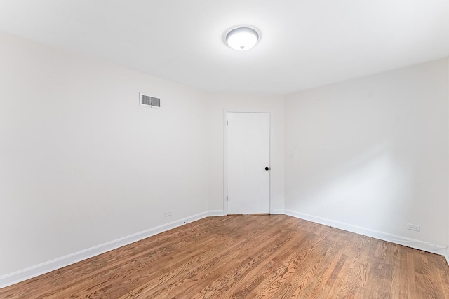 unfurnished room with light wood finished floors, baseboards, and visible vents