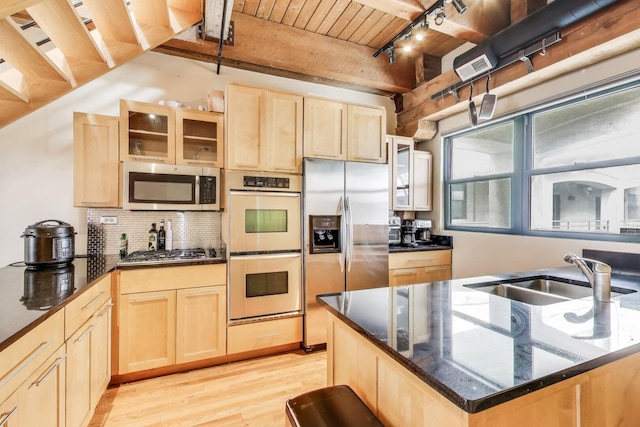 kitchen featuring stainless steel appliances, a sink, light brown cabinets, track lighting, and wooden ceiling