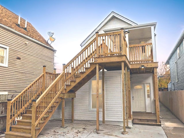 back of house with fence, a wooden deck, and stairway