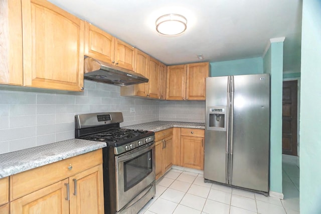 kitchen with under cabinet range hood, appliances with stainless steel finishes, decorative backsplash, and light tile patterned floors