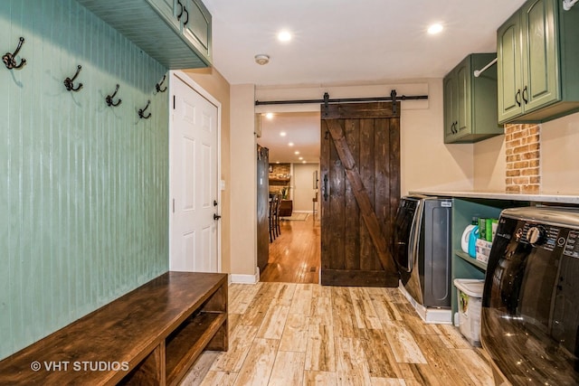 1057 Ponca Dr, Batavia, IL 60510 - laundry area featuring cabinet space, washing machine and clothes dryer, light wood finished floors, a barn door, and recessed lighting