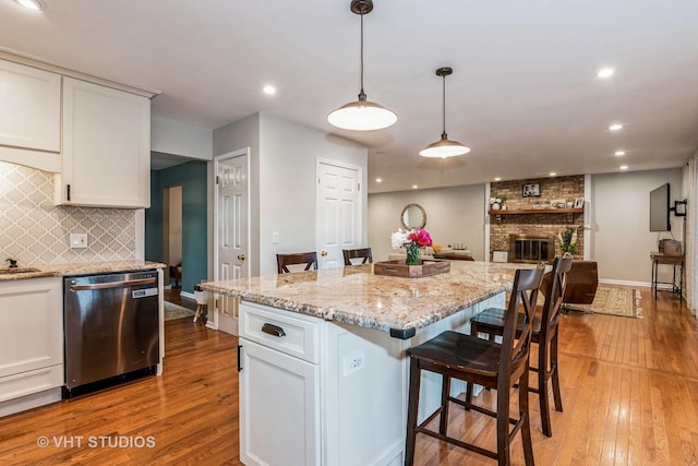 1057 Ponca Dr, Batavia, IL 60510 - kitchen with stainless steel dishwasher, light wood-style flooring, white cabinetry, and recessed lighting