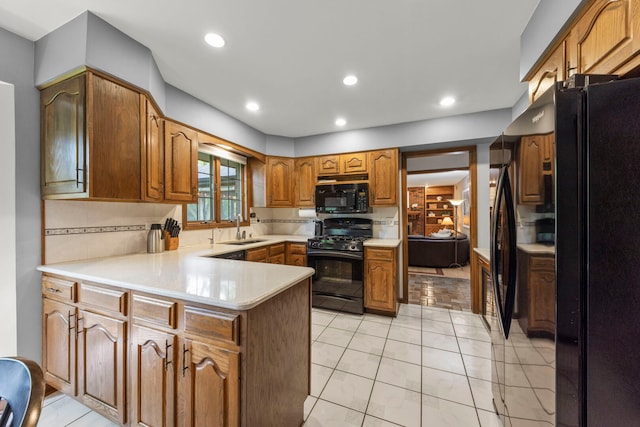 22W281 Mccarron Rd, Glen Ellyn, IL 60137 - kitchen featuring black appliances, a peninsula, light countertops, brown cabinets, and tasteful backsplash