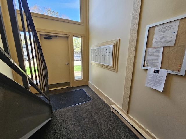 carpeted foyer with baseboards, a baseboard radiator, and mail area